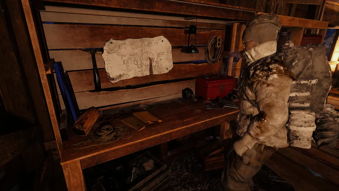 A crafting workbench with a blueprint in a wooden shelter in Permafrost
